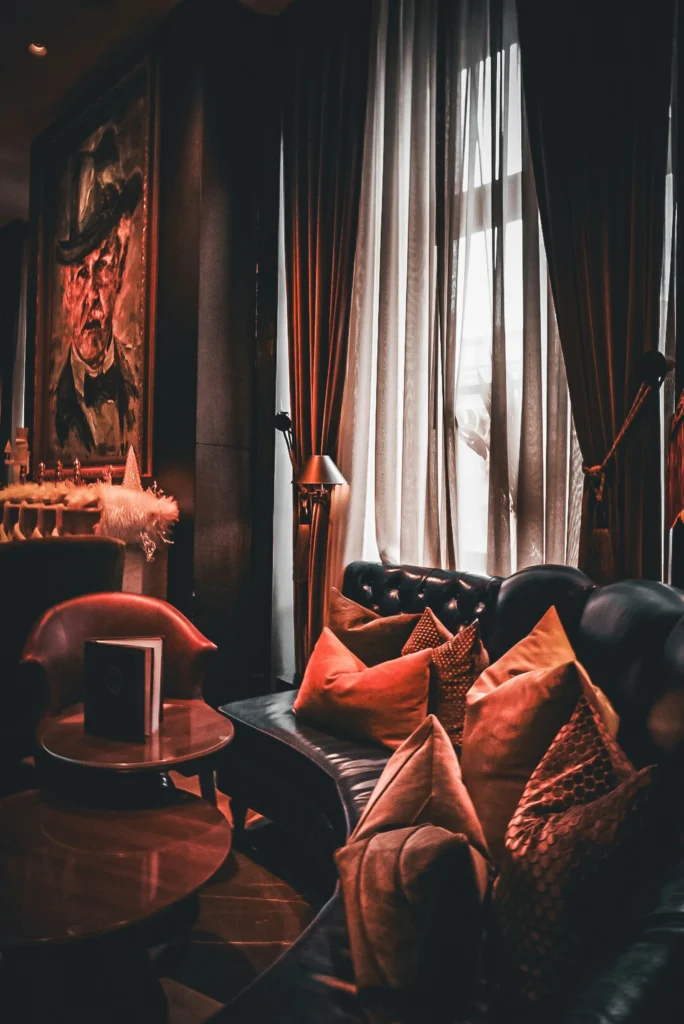 Salon d’hôtel sombre aux coussins rouges