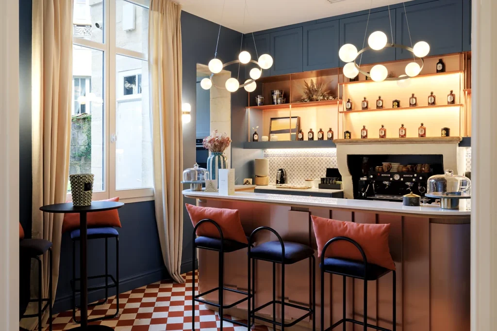 Comptoir de la Clinique Anthèse à Bordeaux, avec assises hautes et étagères éclairées.