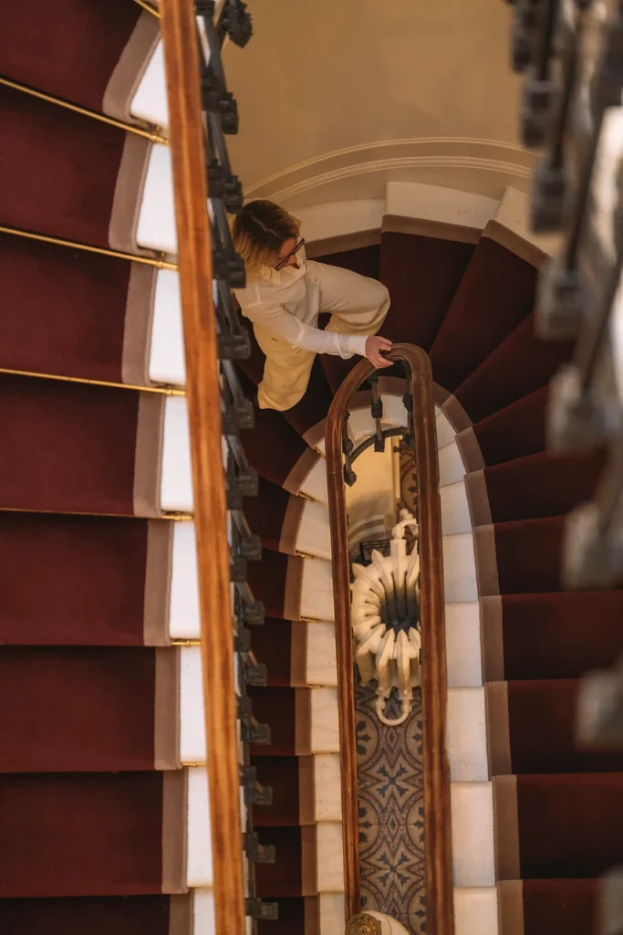 Vue plongeante de l’escalier intérieur de la Clinique Anthèse à Bordeaux, avec une personne en mouvement entre les étages.