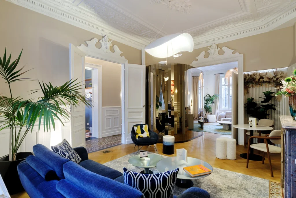 Espace de salon de la Clinique Anthèse à Bordeaux, avec canapé bleu et circulation vers les autres pièces.