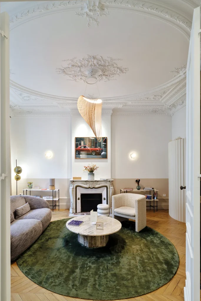 Salon de la Clinique Anthèse à Bordeaux, avec cheminée, mobilier et tapis vert.