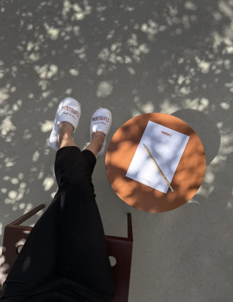 Chaussons Pantoufle près d’une petite table orange.