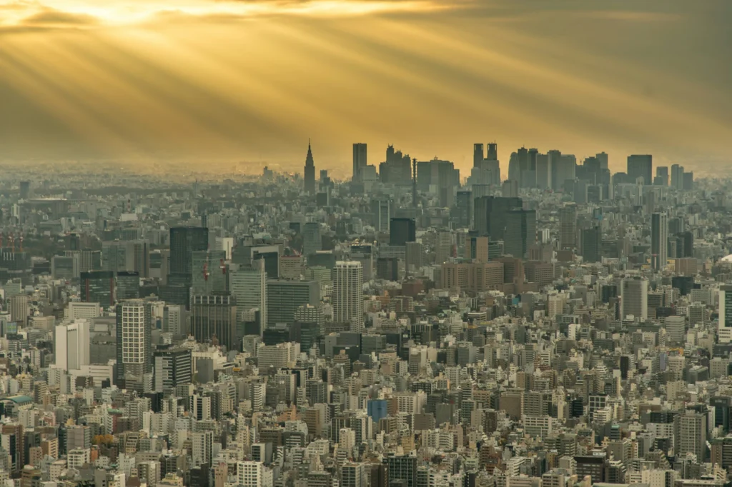 Panorama urbain dense traversé par des rayons de soleil bas.