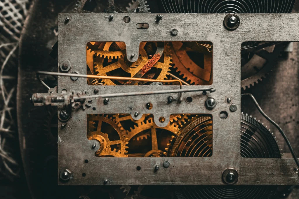 Rouages et mécanisme d’une horloge ancienne éclairés d’une lumière ambrée